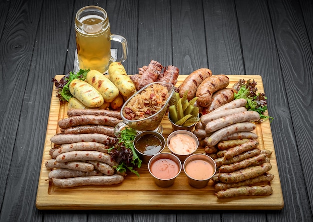 Gegrilde worstjes met glas bier op een houten tafel Premium Foto