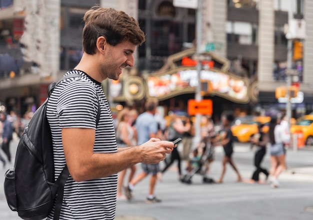 Gelukkig jonge man kijkend naar een smartphone Gratis Foto