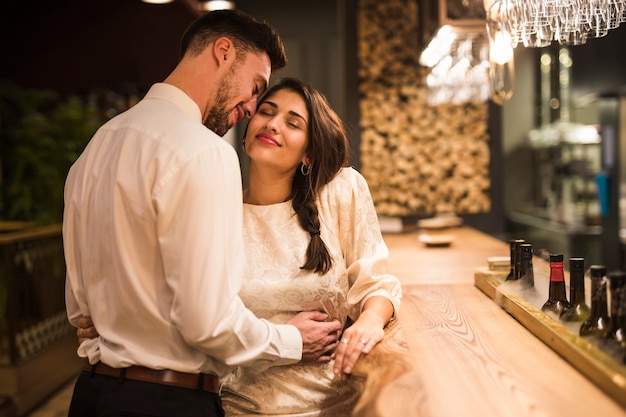 Gelukkige man die vrolijke vrouw koestert bij barteller Gratis Foto