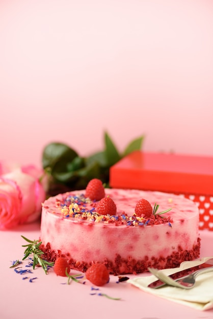 Geschenkdozen, rozen, frambozencake met verse bessen, rozemarijn en droge bloemen. valentijnsdag concept. presenteer met liefde Premium Foto