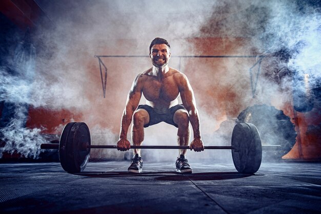 Gespierde Fitness Man Doet Deadlift Een Barbell Boven Zijn Hoofd In Het Moderne Fitnesscentrum Functionele Training Snatch Oefening Rook Op De Muur Premium Foto