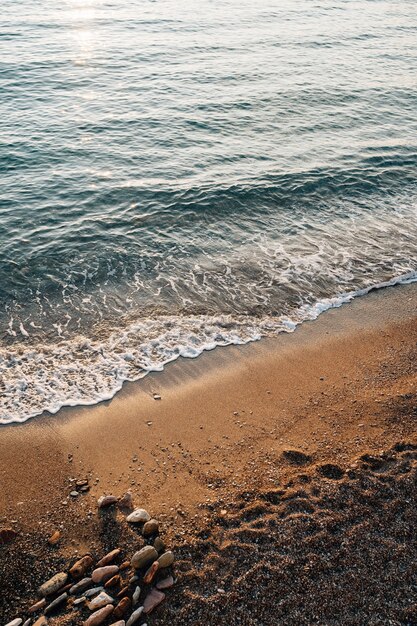 Getijdeboor de golf loopt strand op waar de stenen liggen | Premium Foto