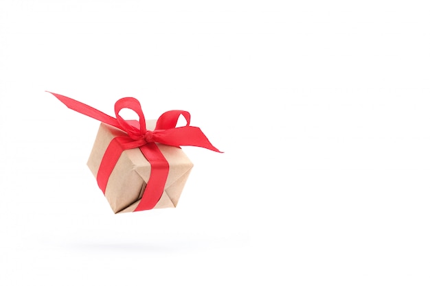 Giftdoos met rood lint dat in lucht op wit wordt geïsoleerd. Premium Foto