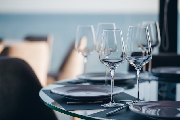 Glazen, bloemvork, mes geserveerd voor het diner in restaurant met gezellig interieur Premium Foto