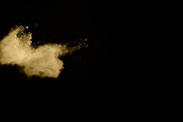 Gouden poederexplosie op zwarte achtergrond. beweging bevriezen. Premium Foto