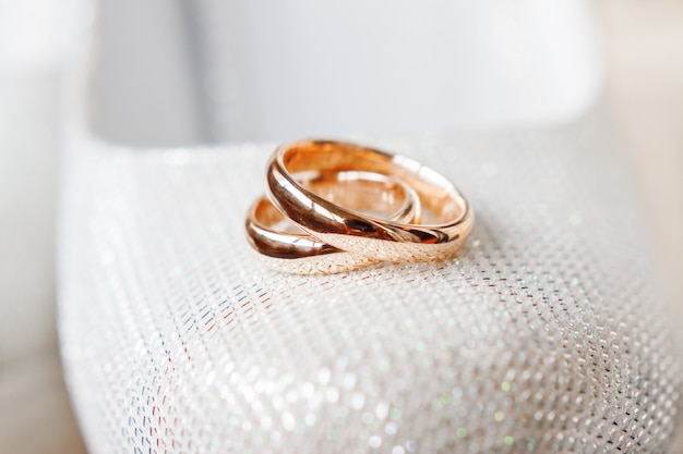 Gouden trouwringen op bruidschoenen met bergkristallen. bruiloft sieraden details. symbool van liefde en huwelijk. Premium Foto