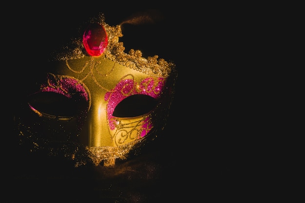 Gouden venetiaans masker op een zwarte achtergrond Gratis Foto