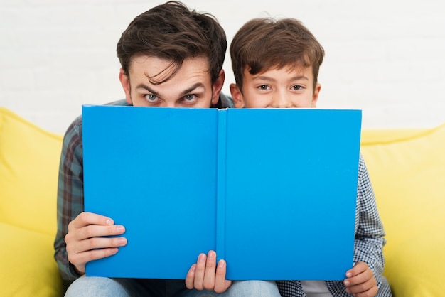 Grappige vader en zoon die hun gezichten bedekken Gratis Foto