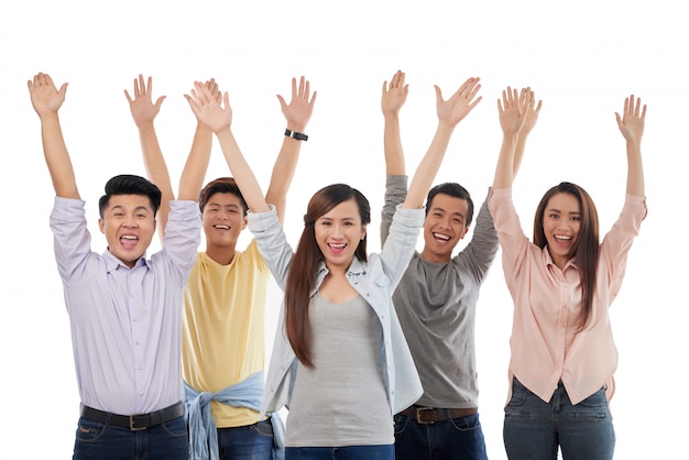 Groep opgewonden terloops geklede mannen en vrouwen die met omhoog handen stellen Gratis Foto