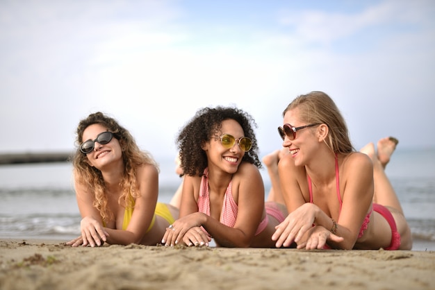 Groep van glimlachende jonge vrouwen het strand het concept geluk Gratis Foto