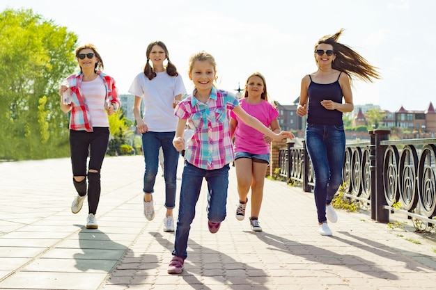Groep van moeders en dochters lopen langs de weg in het park Premium Foto