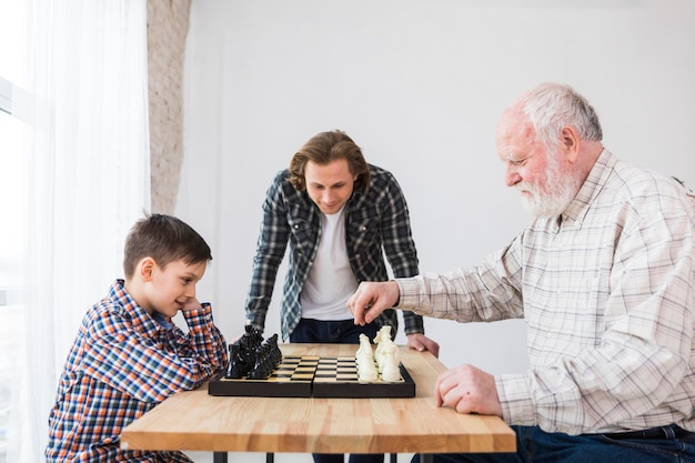 Grootvader en kleinzoon spelen schaak Gratis Foto