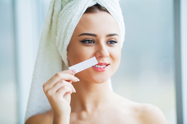 Haarverwijdering wax. suikervrije ontharing van vrouwenlichaam. wax epilatie spa-procedure. procedure schoonheidsspecialist vrouw. snor Premium Foto