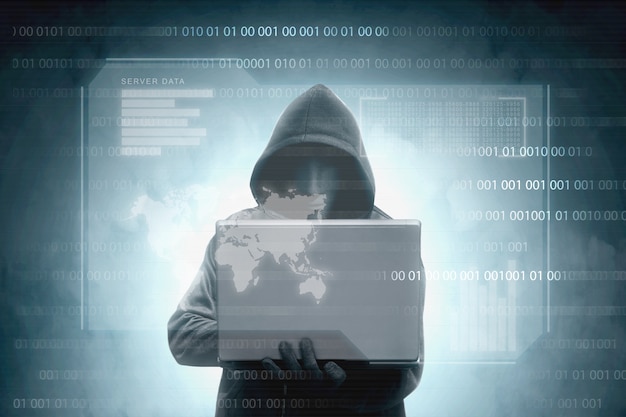 Hacker in zwarte hoodie met laptop met virtuele display servergegevens, grafiekbalk, binaire code en wereldkaart Premium Foto
