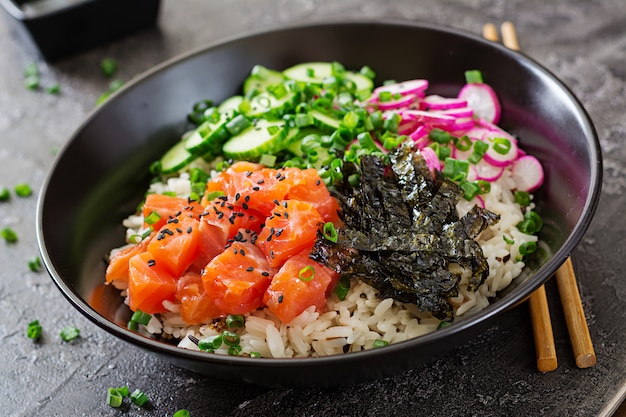 Hawaiiaanse zalm fish poke bowl met rijst, radijs, komkommer, tomaat