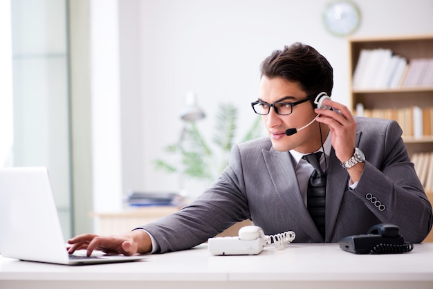 Helpdeskexploitant die op telefoon in bureau spreekt Premium Foto