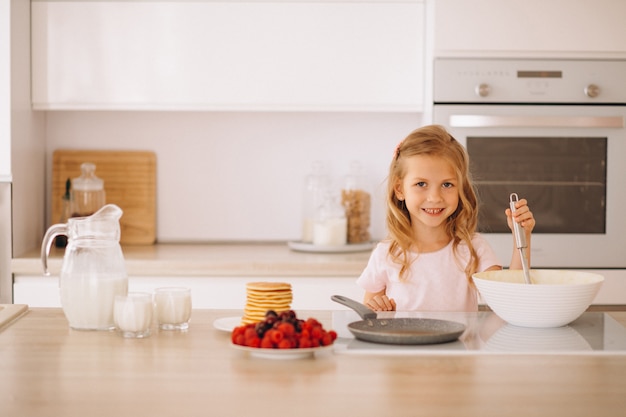 Het bakselpannekoeken van het meisje bij de keuken Gratis Foto