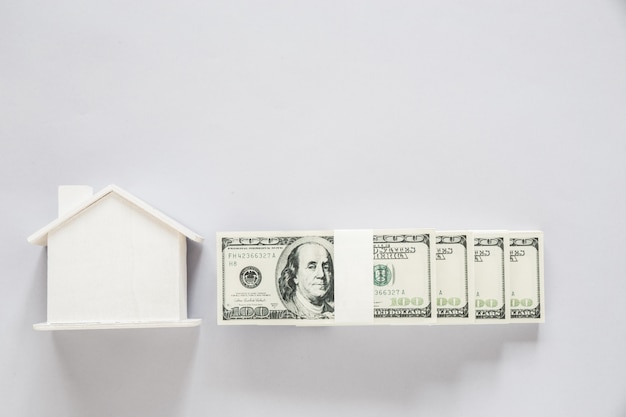 Het bankbiljet van de hoogste meningsdollar met houten huis, financiënconcept Gratis Foto