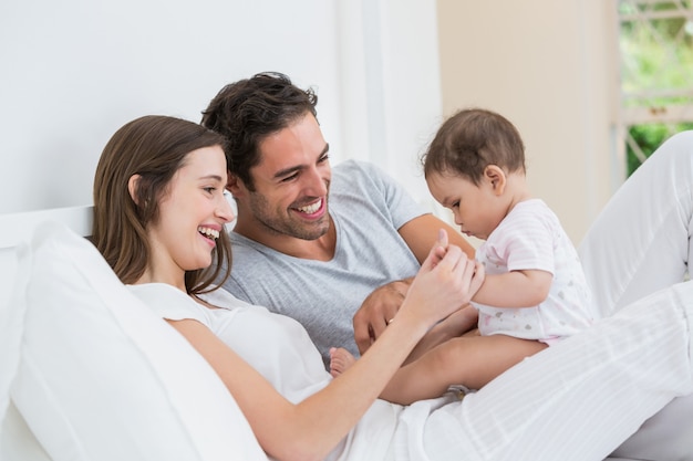 Het vrolijke paar spelen met babymeisje Premium Foto