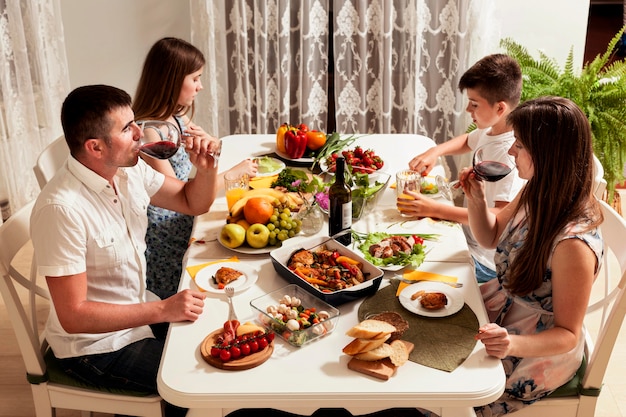 Hoge hoek van familie eten aan tafel Gratis Foto