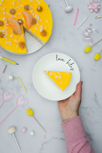 Hoogste mening van de plaat van de handholding met cakeplak Gratis Foto