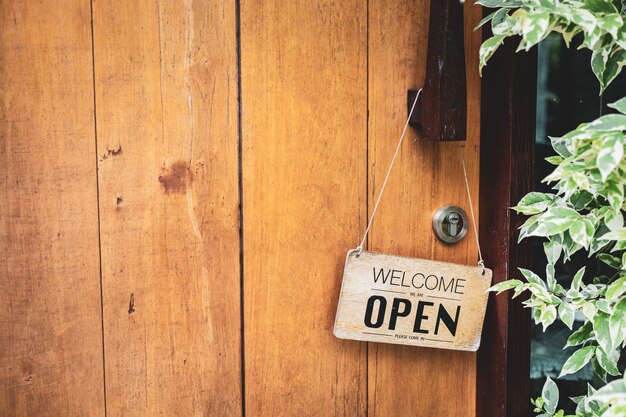 Houten bord met de tekst &quot;we zijn open, kom binnen&quot;, hang aan de