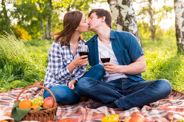 Jong koppel zoenen op picknick Gratis Foto