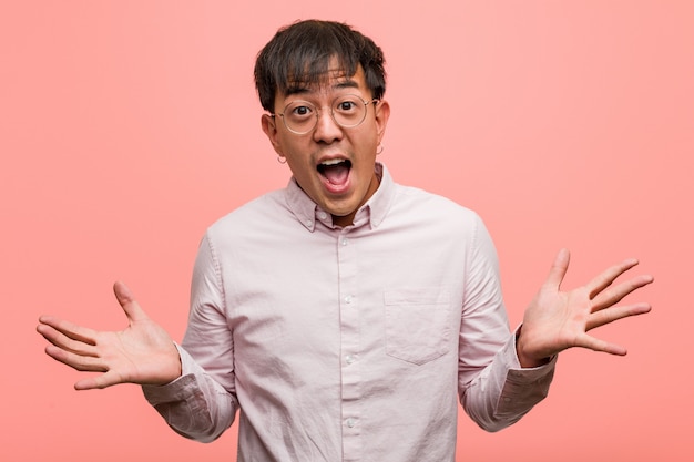 Jonge chinese mens die een overwinning of een succes viert Premium Foto