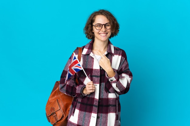 Jonge engelse vrouw die een vlag van het verenigd koninkrijk houdt die