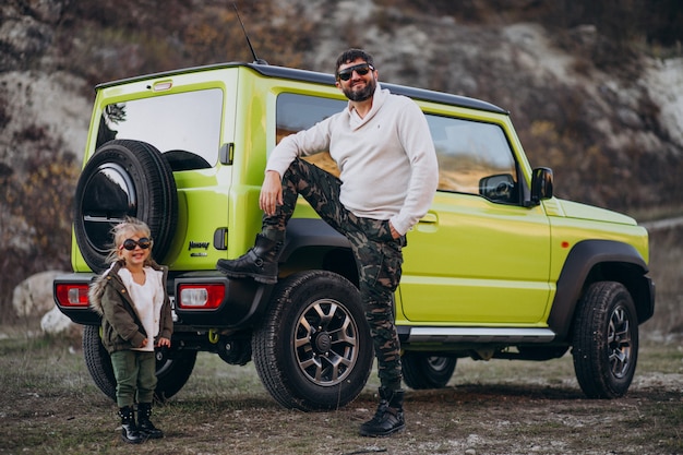 Jonge trendy vader met zijn dochtertje plezier door de auto Gratis Foto