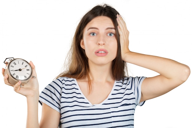 Jonge vrouw met wekker die op wit wordt geïsoleerd. tijd management concept Premium Foto