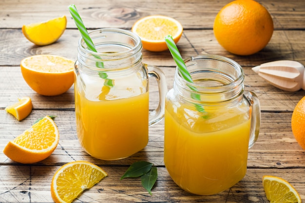  Jus  d orange in glaskruiken en verse sinaasappelen op een 