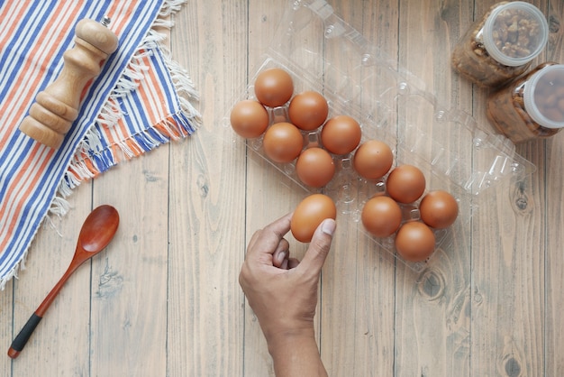 Kies eieren met de hand uit een plastic kist op tafel Premium Foto