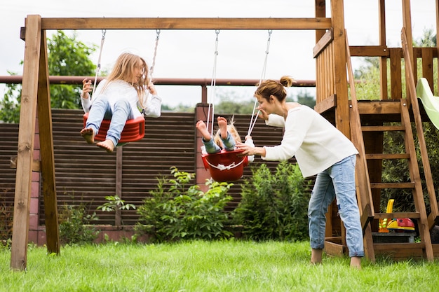 Kinderen op de schommel. meisjes zussen slingeren op een schommel in de