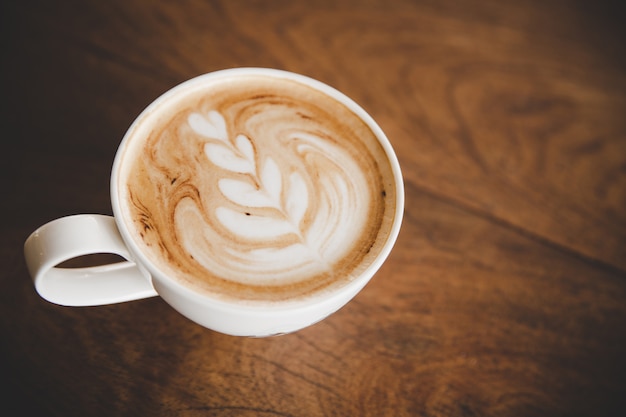 Kop van koffie latte op houten lijst in de koffie van de koffiewinkel Gratis Foto