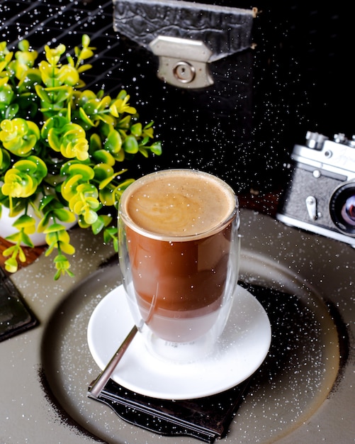 Kopje koffie en plant op tafel Gratis Foto