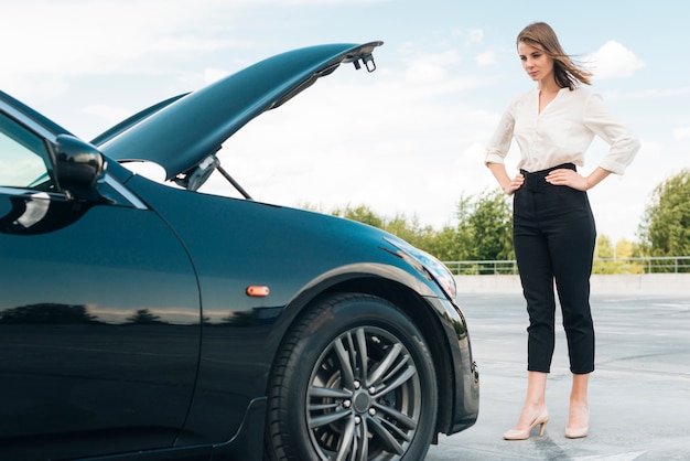 Lang schot van vrouw en auto Gratis Foto