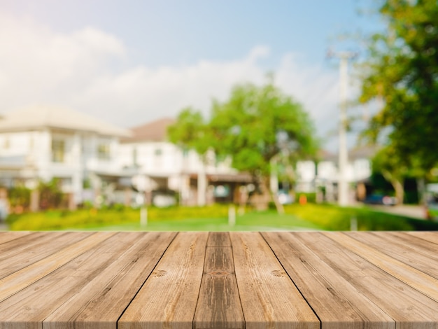 Leeg houten tafelblad op blur abstract groen van tuin en huis in