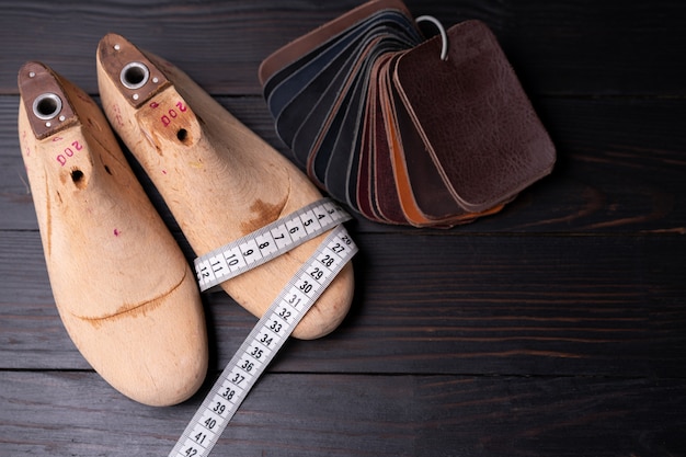 Leermonsters voor schoenen en klomp duren op donkere houten tafel