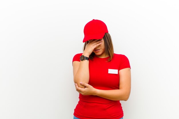 Levering vrouw op zoek gestresst, beschaamd of overstuur, met een hoofdpijn, die gezicht bedekt met de hand Premium Foto