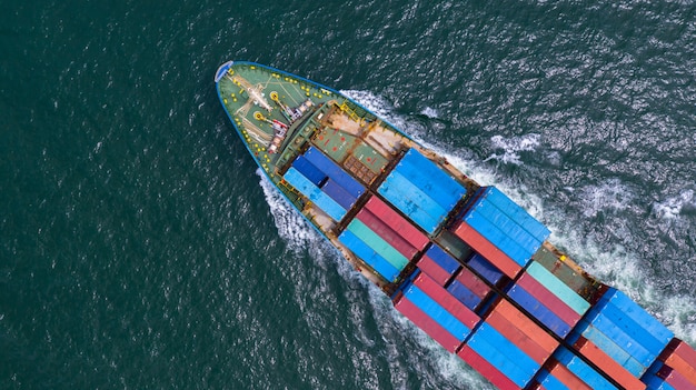 Luchtfoto containerschip uitvoering container in import export zakelijke logistiek en transport van internationaal per containerschip in de open zee. Premium Foto
