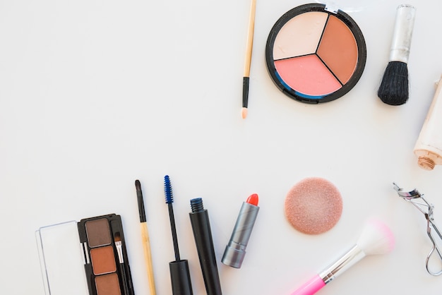 Make-up oogschaduw palet; borstel; spons; lippenstift; mascara op witte achtergrond Gratis Foto