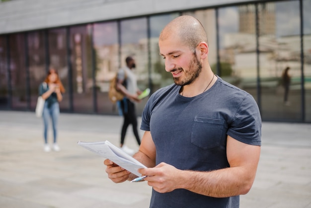 Man die buiten de notitieblok en pen bevindt Gratis Foto