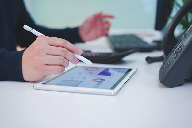 Man hand op tablet met voorraad grafiek dashboard Premium Foto