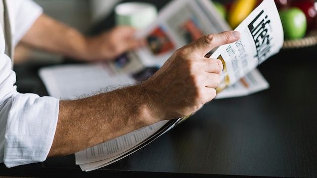 Man's hand met krant Gratis Foto