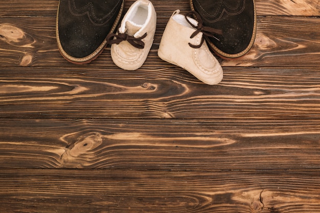 Mannelijke schoenen dichtbij kindlaarzen Gratis Foto
