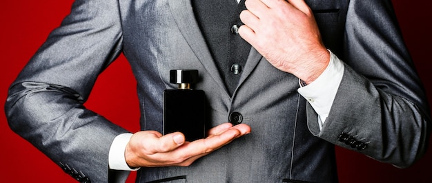 Mannen in de hand op pak achtergrond. geur geur. parfums. mode eau de cologne man in formeel pak, parfum, close-up. | Premium Foto