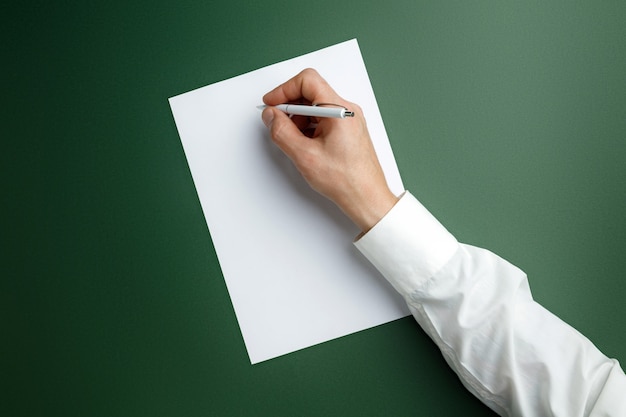 Mannenhand Pen Houden En Schrijven Op Leeg Blad Op Groene Muur Voor