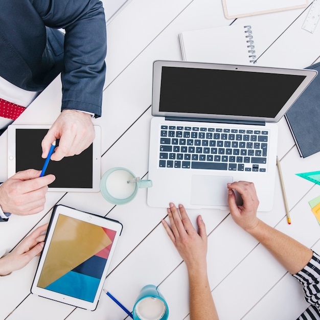 Medewerkers die apparaten gebruiken bij bureau Gratis Foto