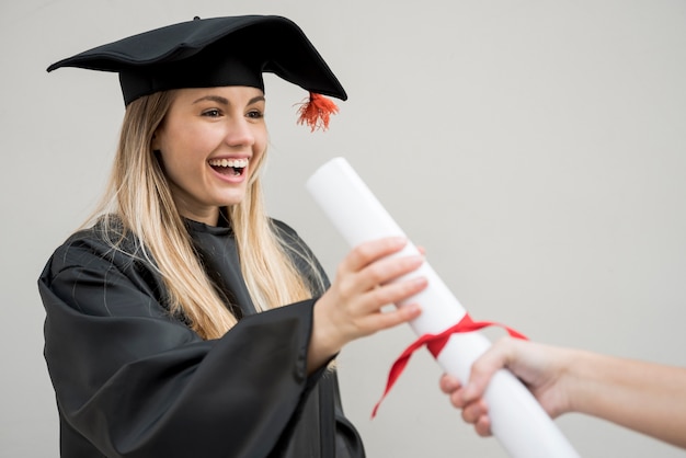 Medium geschoten meisje krijgt haar college certificaat Gratis Foto